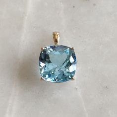 ITEM DESCRIPTION: >>The pendant is made from Solid 14K Yellow Gold. Gemstone used is absolutely natural and ethically sourced. >>Natural Sky Blue Topaz in square cushion shape with prong setting is studded on it with utmost precision. >>This is a minimalist design and is absolutely hassle-free and everyday jewelry. Gem: Sky Blue Topaz Gem size: 15 x 15 mm square cushion Gem weight: 16.00 carats Gold purity: 14K (58.33% approx.) Gold weight: 1.38 grams Gross weight: 4.58 grams The Gold purity is Blue Cushion Cut Jewelry With Gemstone Accents, Blue Aquamarine Cushion Cut Jewelry, Blue Cushion Cut Aquamarine Jewelry, Blue Topaz Gemstones With Prong Setting, Elegant Large Blue Gemstone, Cloudless Sky, Blue Topaz Jewelry, Handmade Jewelry Box, Blue Topaz Pendant