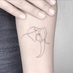 a woman's arm with a single line drawing of an elephant on the wrist