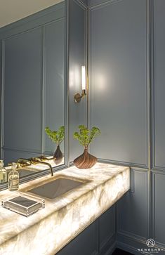 a bathroom sink sitting under a mirror next to a faucet and soap dispenser