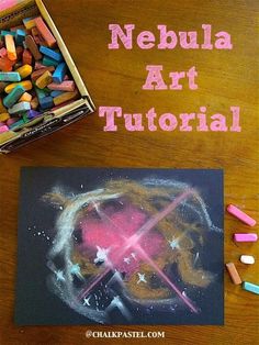 a wooden table topped with chalk and crayons next to a box of colored pencils