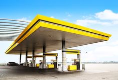 a yellow and white gas station with cars parked at it