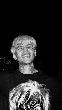 a man with blonde hair and piercings smiling