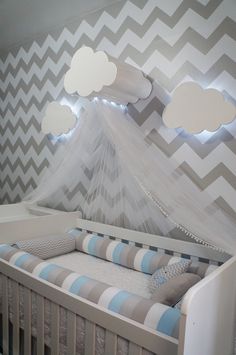 a baby's crib is decorated with gray and white chevrons