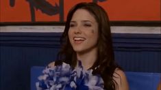 a woman sitting in a chair holding a cheerleader's pom pom