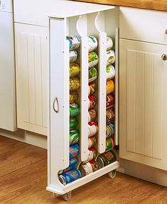 a kitchen cabinet filled with lots of cans and cans in the bottom drawer, next to a counter top