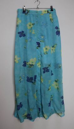 "a vintage sheer blue and yellow floral button-down midi-skirt with a knee-length underskirt ✿ IMPORTANT INFORMATION: * good vintage condition - rip pictured (price reduced) * size: medium - please check exact measurements below (they're there for your benefit!) ✿ MEASUREMENTS (taken while item is lying flat, some measurements will need to be doubled): * length: 38\" (97cm) * waist: 13.5-16\" (34-41cm) - elasticated * hips: 23\" (58cm) ✿ free UK shipping on orders over £100 with code STRAWBERRY Summer Button-up Flowy Skirt, Spring Buttoned Skirt For Beach, Spring Beach Skirt With Buttons, Buttoned Skirt For Spring Beach Outings, Summer Daywear Skirt With Buttons, Daywear Long Skirt With Buttons, Long Skirt With Button Closure For Daywear, Vintage Skirt With Button Closure For Summer, Blue Bottoms With Button Closure For Daywear