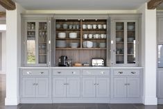 a kitchen with gray cabinets and white dishes