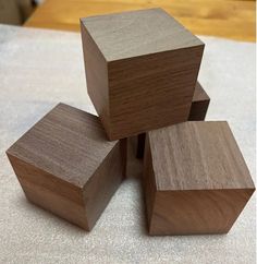 four pieces of wood stacked on top of each other in the shape of cubes