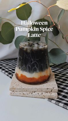 halloween pumpkin spice latte on a black and white checkered tablecloth with leaves