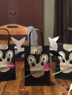 three paper bags with faces on them sitting on a table