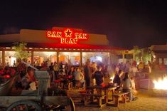 many people are gathered around the fire pit at san francisco's fan city bar