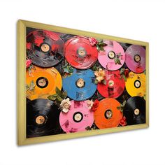 an art piece with many different colored records on it's sides and flowers in the middle