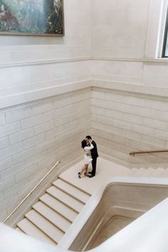 a bride and groom are standing on the stairs at the top of an escalator