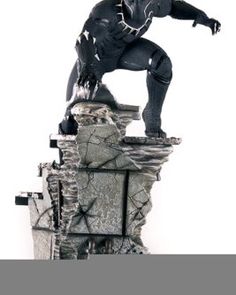 the black panther statue is standing on top of a broken building with his arms outstretched