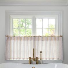 a white bath tub sitting under a window