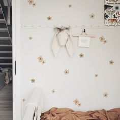 a bedroom with white walls and flowers on the wall