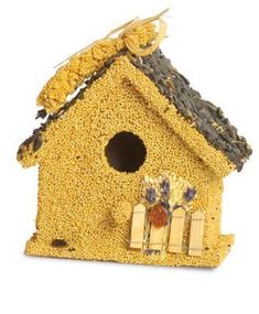 a yellow bird house with flowers on the roof