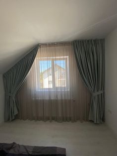 an empty room with a window and curtains