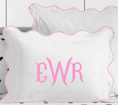 two white pillows with pink scalloped edges and the word eyr on them