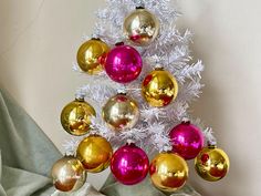 a white christmas tree with red and gold ornaments