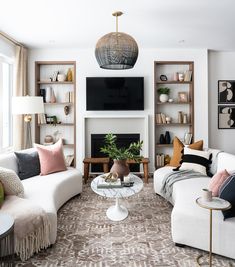 a living room filled with furniture and a flat screen tv mounted on the wall over a fire place