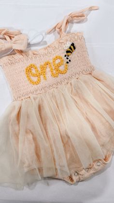 Beautiful one romper for your little babe. This listing is for a beige peach  romper, one lettering in off white and a bee appliqué next to it.  the sweetest bee ONE romper, perfect for you first bee-day celebration.  Birthday photoshoots, special events, etc. If you'd like a different color or saying, don't hesitate to contact us First Bee Day Photoshoot, Bee Themed One Year Birthday, Happy First Bee Day, First Birthday Honey Bee Theme, Bee One Birthday Party, First Birthday Themes Bee, Bee Day Party Ideas 1st, Bee Theme 1st Birthday