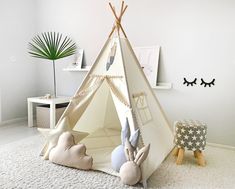 a child's teepee tent in the corner of a room with white carpet