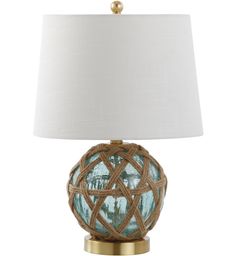 a blue glass lamp with a white shade on the base and a gold metal base