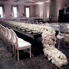 a long table with white flowers and chairs