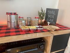 a table topped with lots of food next to a sign that says trail mix bar