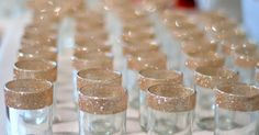 there are many glasses that have gold glitter on the rims and they are lined up