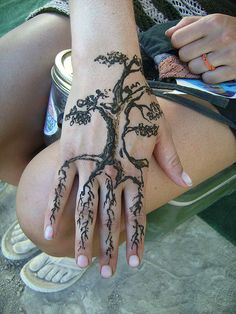 a woman's hand with a tree tattoo on it