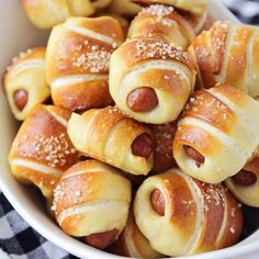 a bowl filled with hot dogs wrapped in bread