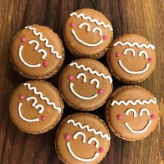 six gingerbreads with icing and smiling faces on them