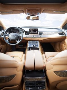 the interior of a luxury car with dashboard, steering wheel and center console in tan leather