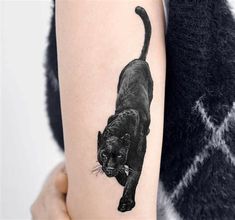 a black cat tattoo on the arm