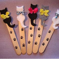 six wooden cats with bows and paws on them are sitting next to each other in the shape of toothpicks