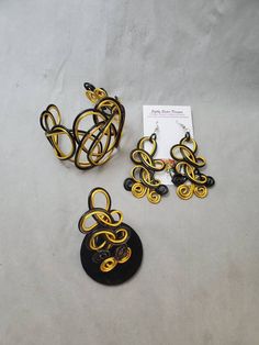 "Black and gold colored jewelry set, this beautiful cuff bracelet, ring, and matching earrings are a statement set that will get plenty of compliments. Made of non-tarnish, lightweight aluminum wire. The cuff is adjustable and the earrings are 3\" long with surgical steel ear wires. Be sure to choose your ring size. I want my customers to be happy, so please look carefully at the photos, and feel free to ask any questions. I post new items as soon as they are created so please come back and visi Handmade Adjustable Gold Jewelry Sets, Wire Wrapped Bracelet For Parties, Handmade Gold Bracelet For Evening, Wire Wrapped Bracelet For Party, Elegant Yellow Cuff Bracelet As Gift, Elegant Yellow Metal Jewelry, Adjustable Gold Jewelry Sets With Matching Earrings, Adjustable Gold Jewelry For Evening, Gold Adjustable Jewelry For Evening