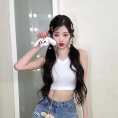 a girl with long black hair and white shirt holding a teddy bear