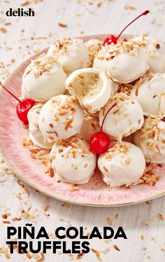 a pink plate topped with ice cream and cherries on top of toasted coconut flakes