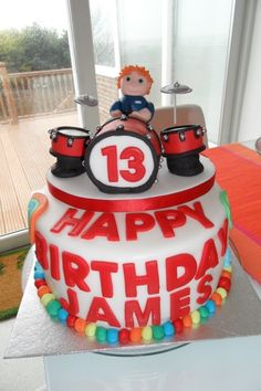 a birthday cake with a toy drummer on top