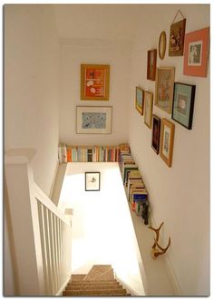 the stairs are lined with books and pictures