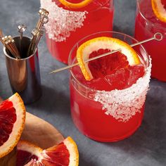 blood orange margaritas are garnished with sugar and silver serving utensils