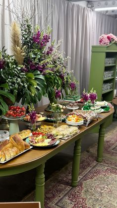 a buffet table filled with lots of food and flowers on it's tablespread