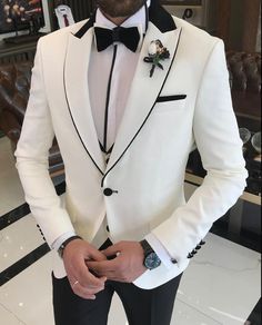 a man wearing a white tuxedo with black lapels and a bow tie