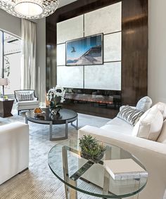 a living room filled with furniture and a glass table in front of a window on top of a hard wood floor