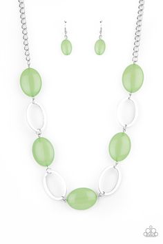 a necklace and earring set with green glass beads on a chain, hanging from a white background