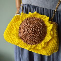 a crocheted purse with a sunflower on the front and bottom, hanging from a chain