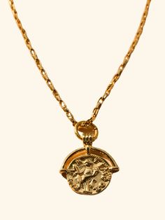 The Roman Coin Necklace combines a delicate gold link 18 kt. Gold plated chain and a detailed Roman coin pendant, exuding sophistication and historical charm. Each intricate link in the chain complements the intricacies of the coin, creating a timeless and refined accessory perfect for any occasion. 18 Inches in length +2 inch extender Complete your look with The G Necklace. Gold Plated Coin Pendant Necklace, Yellow Gold Medallion Coin Necklace With Adjustable Chain, Brass Coin Necklace With Adjustable Chain, Yellow Gold Medallion Necklace With Adjustable Chain, Vintage Gold-tone Chain Necklace With Coin Pendant, Elegant Gold-tone Coin Necklace, Gold Coin Pendant Necklace With Figaro Chain, Gold Coin Necklace With Figaro Chain Pendant, Brass Medallion Chain Necklace With Coin Pendant