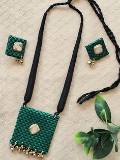 a green and black beaded necklace with matching earrings